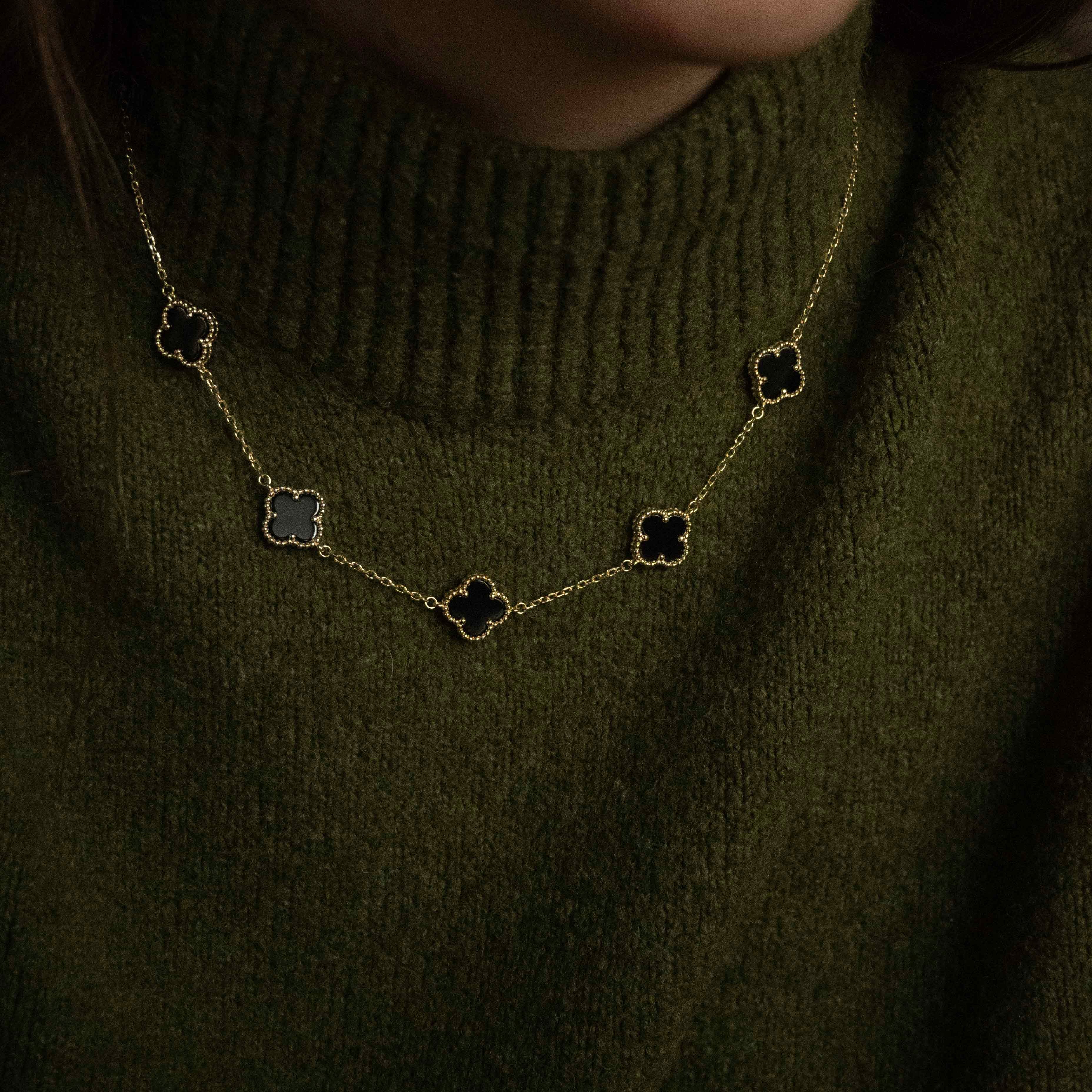 Колие Five Clover от сребро с 14К златно покритие, носено на човек в зелен пуловер.