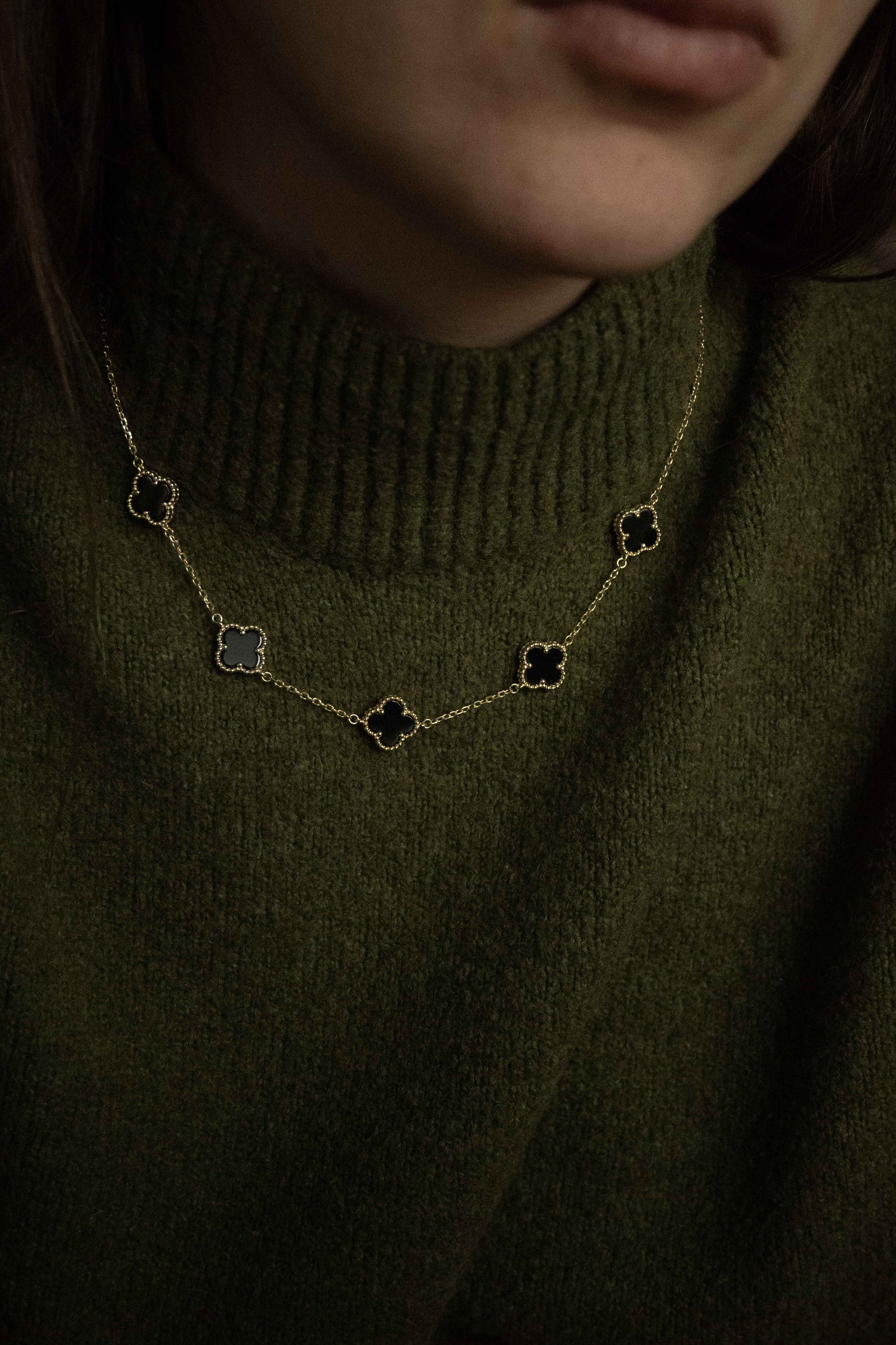 Колие Five Clover от сребро с 14К златно покритие, носено на човек в зелен пуловер.