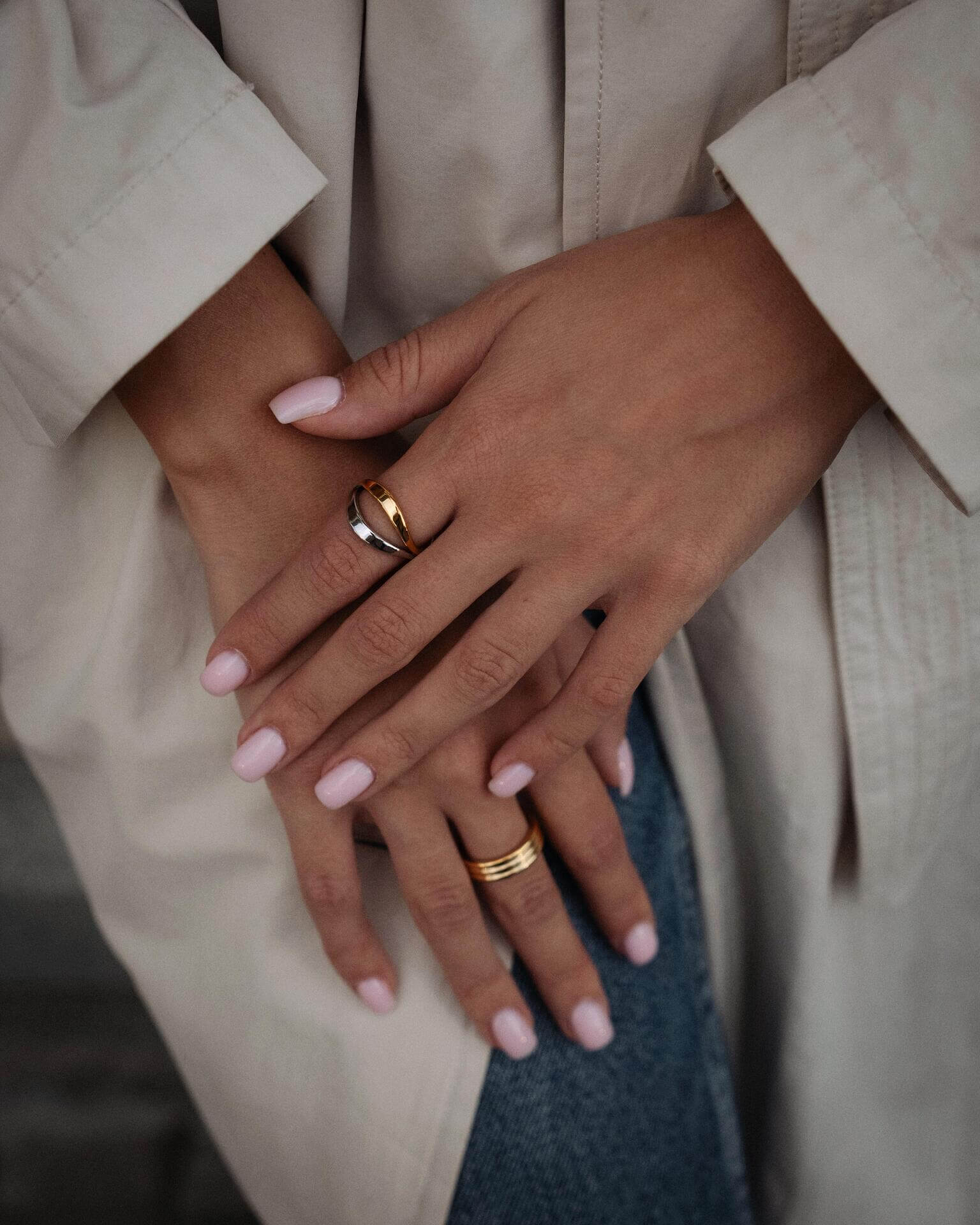 Ръце с пръстени, включително хибриден пръстен с 18К златно покритие, носени с модерен стил.