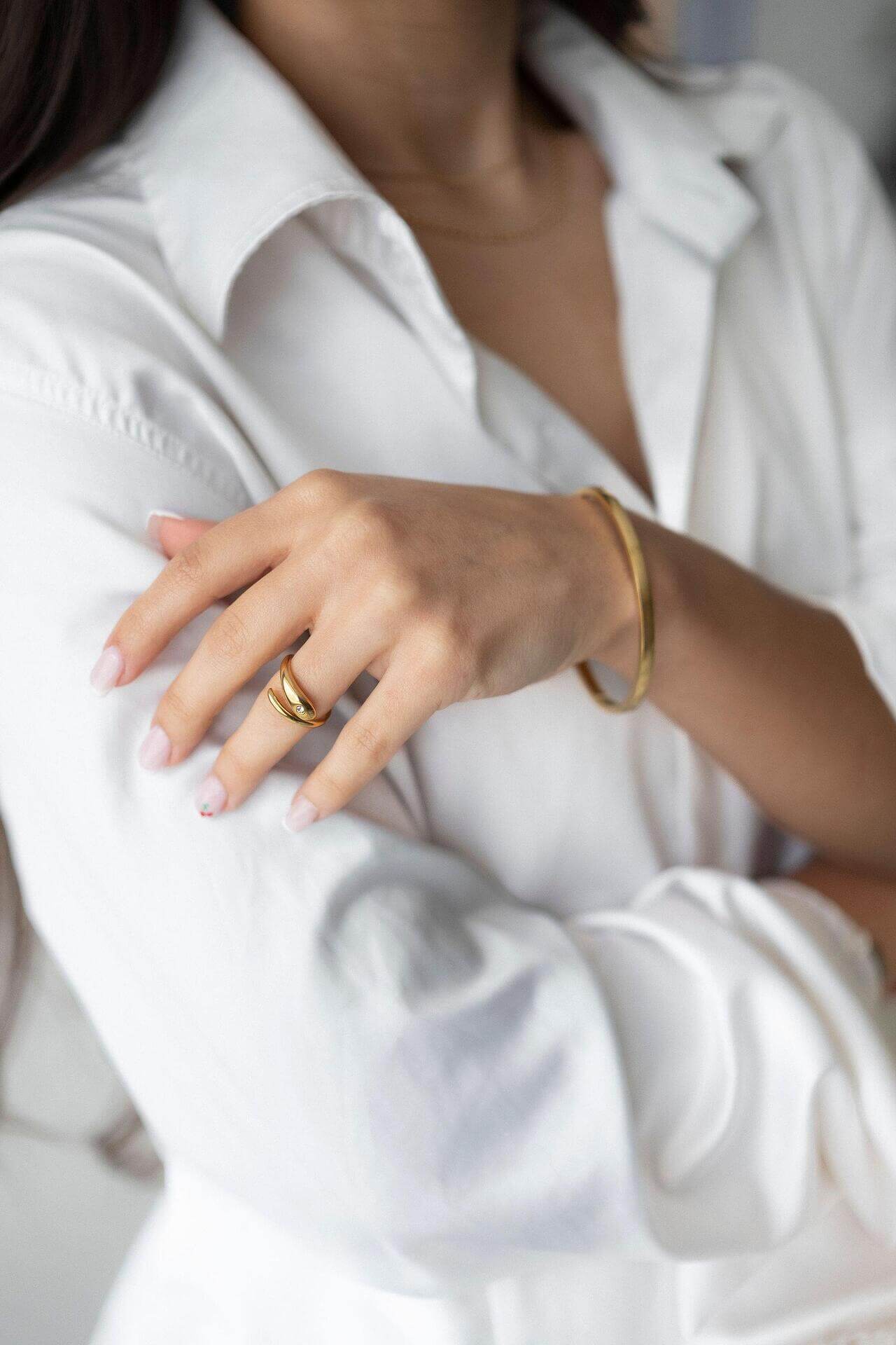 Elegant model showcasing 'Пръстен Lyna' ring in gold plating with a stylish white shirt.