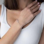 Сребърна гривна с форма на сърца, модел S925, носена от жена с изправена коса.