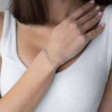 Сребърна гривна с форма на сърца, модел S925, носена от жена с изправена коса.